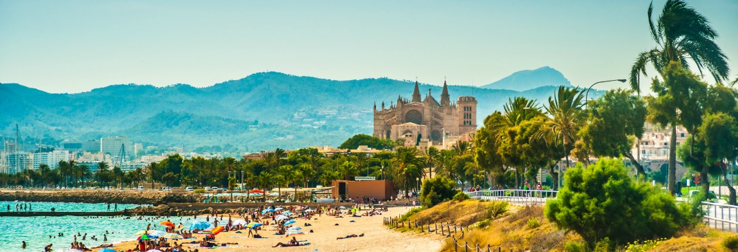 Kathedrale mit Strand und Bergpanorama in Palma de Mallorca.